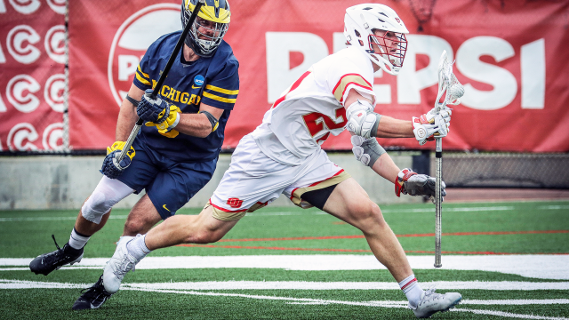 Denver's Mic Kelly sprints past a Michigan defender in an NCAA men's lacrosse tournament first-round game at Peter Barton Lacrosse Stadium.